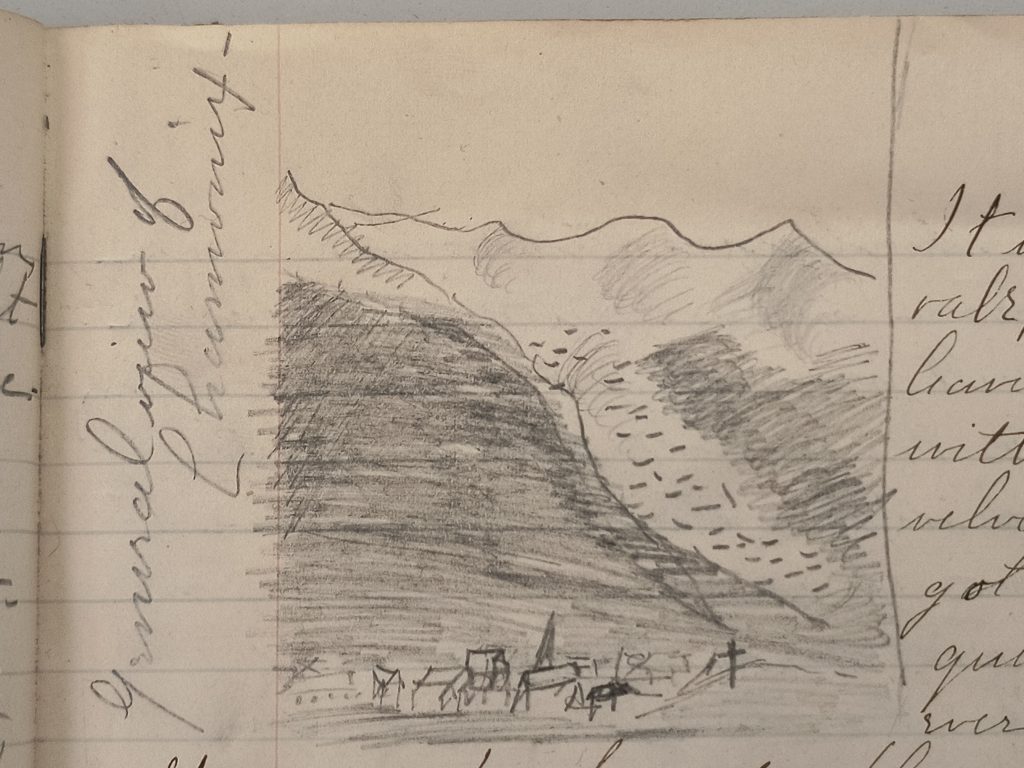 Color photograph of a pencil sketch drawn on part of a manuscript page, labeled sideways in the left-hand margin “General view of Chamonix.” The sketch depicts a view of multiple mountain peaks with small buildings in the foreground.